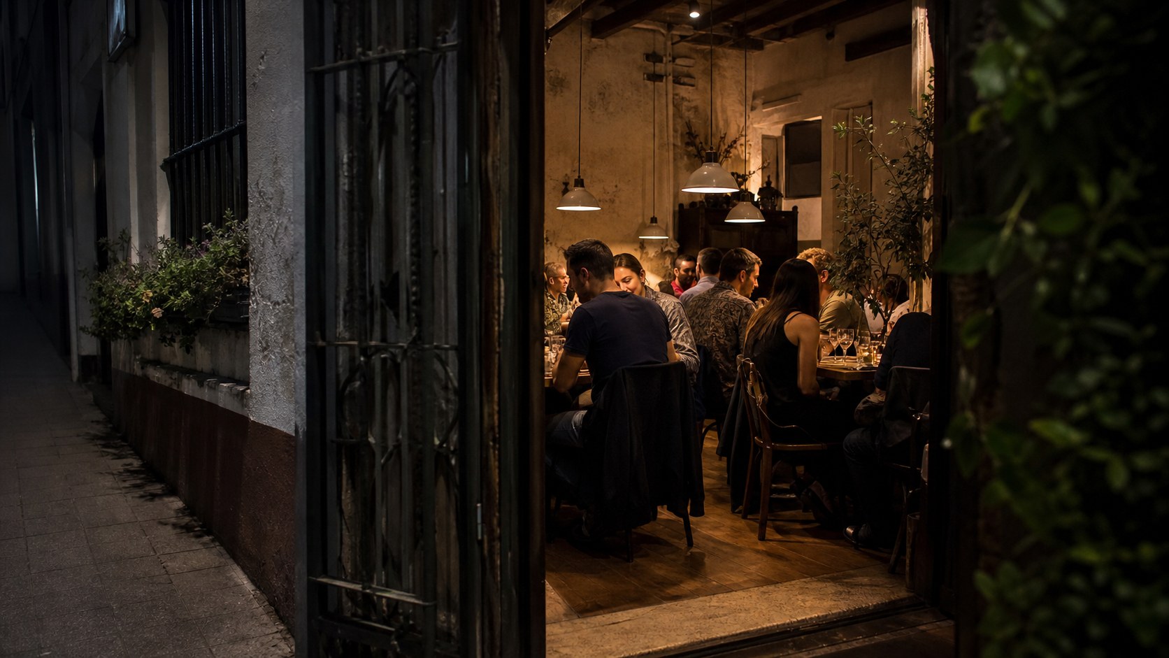 Discreet cozy neighborhood restaurant doorway with diners inside at night